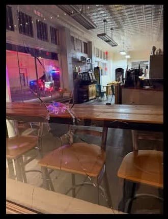Cracked front window of the Gallup Coffee Company after a rock was thrown through it